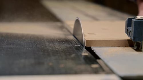 Artisan masculin travaillant dans une usine de meubles, attachant du tissu à un cadre en bois avec un professionnel