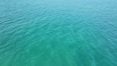Flying over the ocean at sunset. Aerial view of drone flight over sea in sunset.