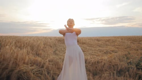 Female in White Dress on Field Dancing and Moving Gracefully