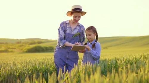 Woman and Girl in Field with Tablet Technology