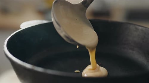Pancake Batter Poured into Black Skillet Close Up