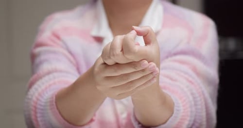 Nahaufnahme einer Frau mit Selbstmassage und Entspannungsarthritis, bei der Finger und Arm nach ihrer Hand gestreckt werden
