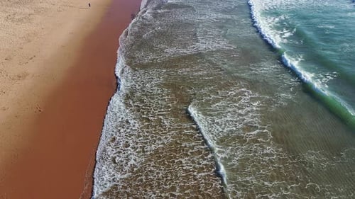 Vue aérienne de la plage tropicale, vue de dessus des vagues qui se brisent sur une plage de sable jaune tropicale. Les vagues de la mer sont sans faille