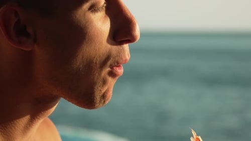 Man Eating Orange Ocean Coast Sun