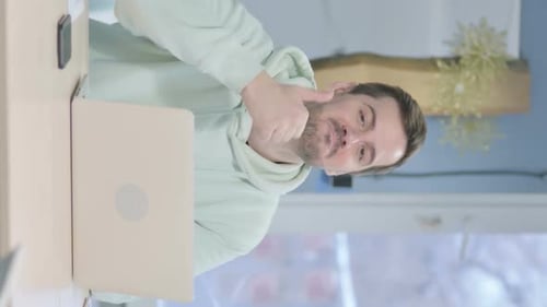 Man Waving and Giving Thumbs Up to Laptop