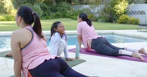 Diversas amigas recostadas en la espalda en colchonetas junto a la piscina, cerca de una botella, un día soleado para hacer ejercicio