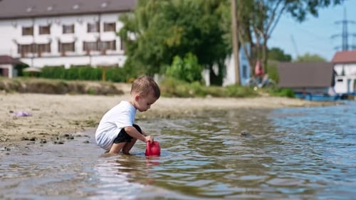 Small boy on river beach playing. Water activity lifestyle.