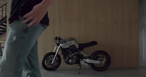 Motorcycle storage at modern apartment near wooden wall and man passing away
