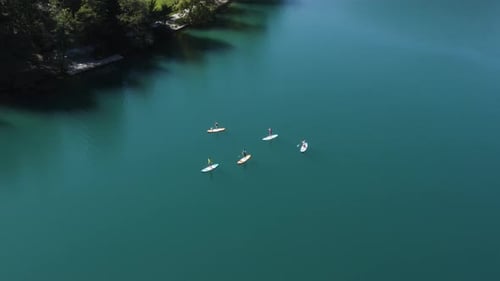 Aerial View Of People Standup Paddleboarding At Lake Bled In Slovenia.