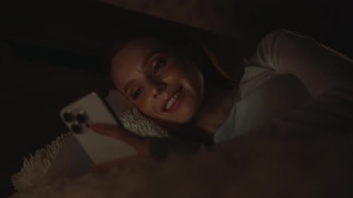 Woman Using Phone in Bed at Night