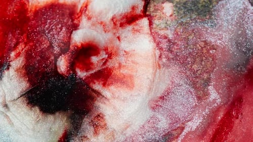 Expandierende Welle aus dicker roter Tinte mit Glitzer. Ansicht