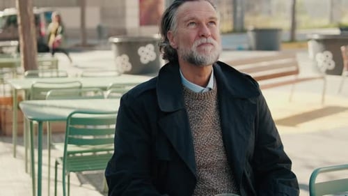 Contemplative Senior Man in an Outdoor Cafe