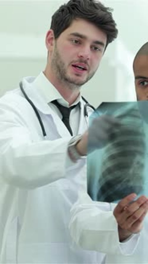 Trois médecins confiants examinent une radiographie de poumons sains dans un hôpital lumineux