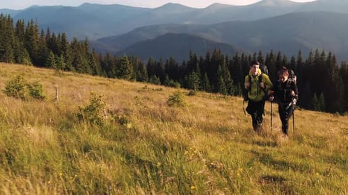 Couple of tourists walks up on hill. Majestic Carpathian Mountains. Beautiful landscape of untouched