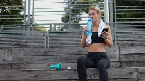Woman Resting after Workout Using Smartphone