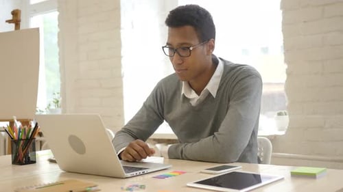 Man Working at Computer Gives Thumbs Up