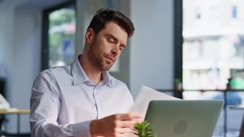 Man Working on Laptop in Bright Office