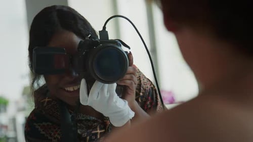Woman Photographer Adjusts Camera for Portrait