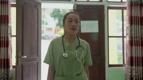 Slow Motion Nurse Walking Into Rural Clinic with Natural Light