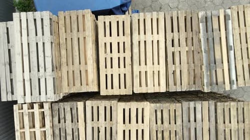 Plan de haut en bas montrant des palettes en bois empilées dans l'entrepôt. Pile de différents types de palettes dans une boîte