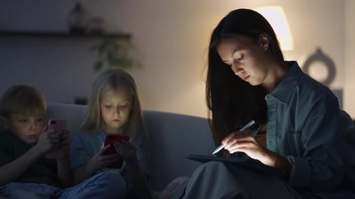 Family using digital devices in the evening at home