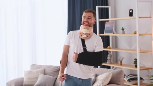 Man with Injury Smiling with Neck Brace and Sling
