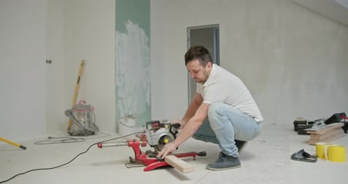 Man Cuts Wood During Home Renovation and Painting