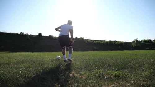 Professional Footballer in Uniform Shows Tricks with Ball While Running at Green Field Sportsman