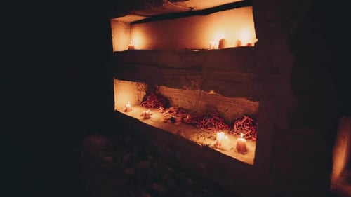 Kerzen beleuchten einen Altar in einem schwach beleuchteten Raum während eines kulturellen Rituals
