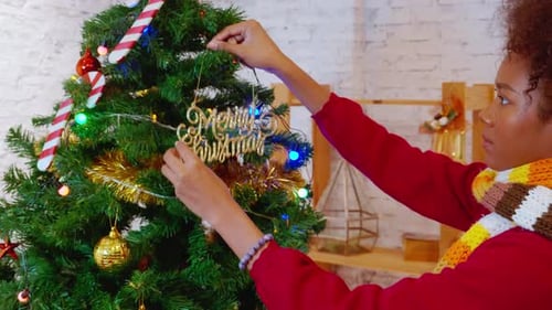 Woman Decorating Christmas Tree with Ornaments