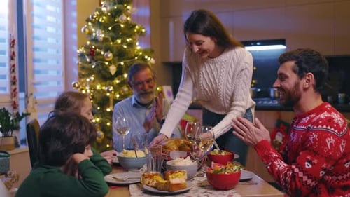 Family Christmas dinner with parents, children, grandfather indoors