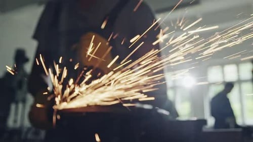 Closeup View of Flying Sparks From Angle Grinder in Use By Anonymous Worker