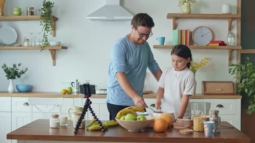 Un padre con una linda hija bloguea sobre cocina, videoblog sobre alimentación saludable, un padre