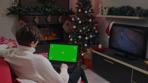 Man on video call on Green Screen laptop during Christmas holiday.