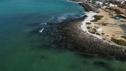 Aerial view of sandy beach and ocean waves, Spain.