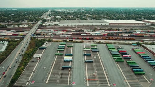 Large Freight Terminal next to a Train Cargo Complex with Wagons and Trailers of Difrent Colors next