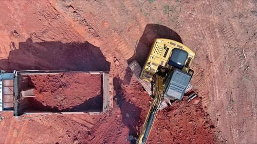 Excavator Fills Truck with Soil at Rural Site