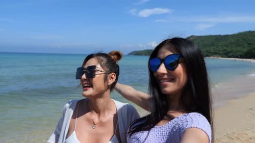 Beautiful young woman standing on beach and taking selfie smile