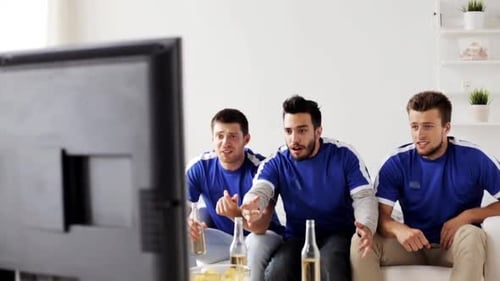 Enthusiastic Men Cheer While Watching TV at Home