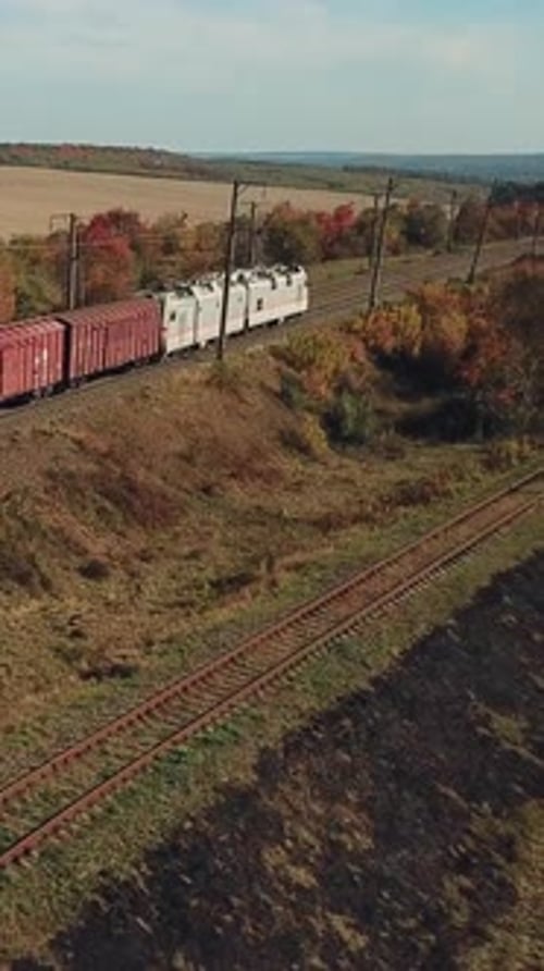 freight train with building materials is passing by rail to the destination. Aerial view