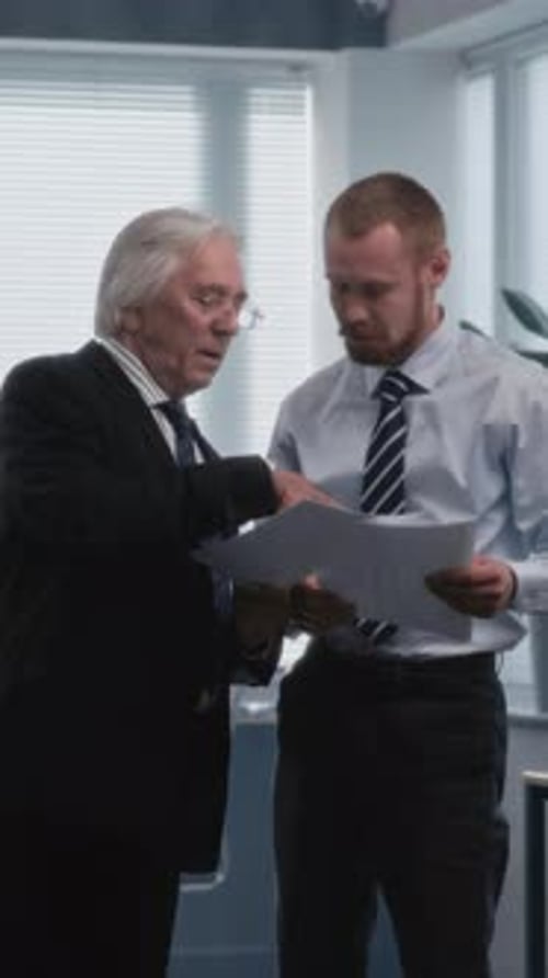 Two Different Businessmen Discussing Financial Market Data