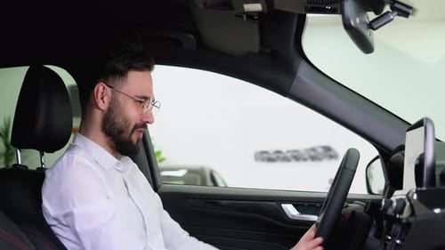 Happy Man Sits in New Electric Car in Shop Dealership and Celebrate Purchase of New Vehicle