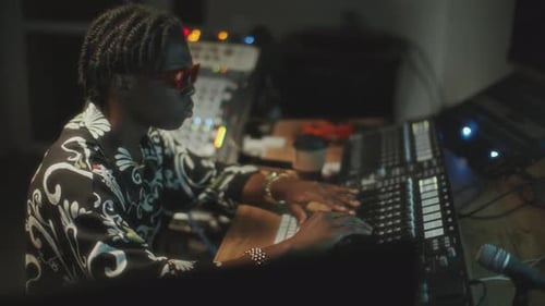 African American Sound Engineer Mixing Audio in Music Recording Studio