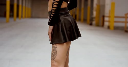 Back view of feminine silhouette with tattoo and black skirt