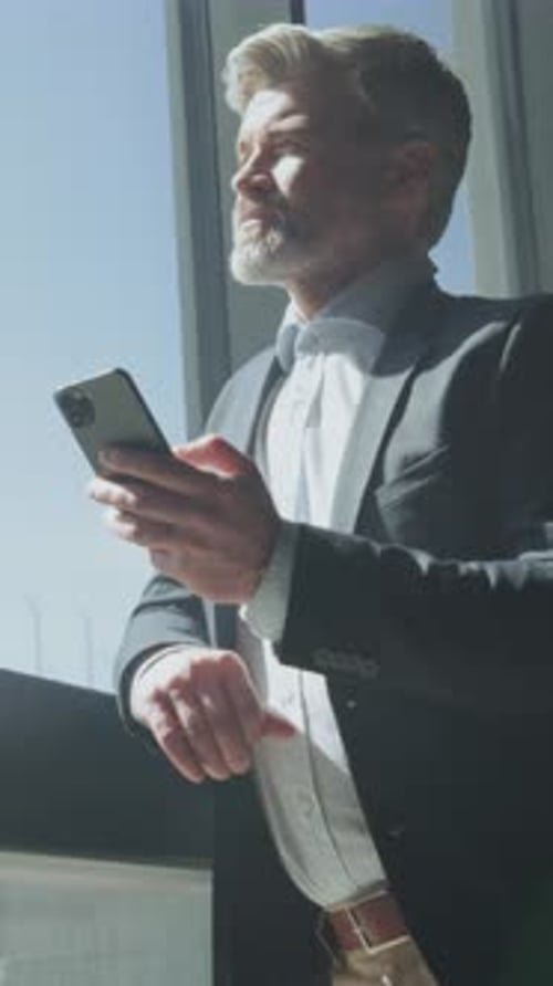 Man in Suit Uses Phone in Office Building