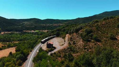 Vista aérea do trem de passageiros entrando no túnel na paisagem montanhosa