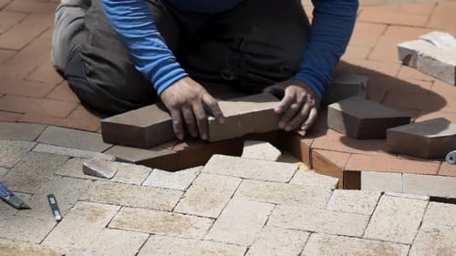 Adult Installing Brick Pavers Outside