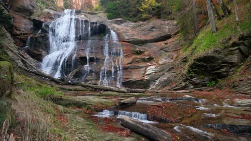 Beautiful waterfall streaming down rocks in autumn forest. Waterfall Kozice, Bosnia and Herzegovina.