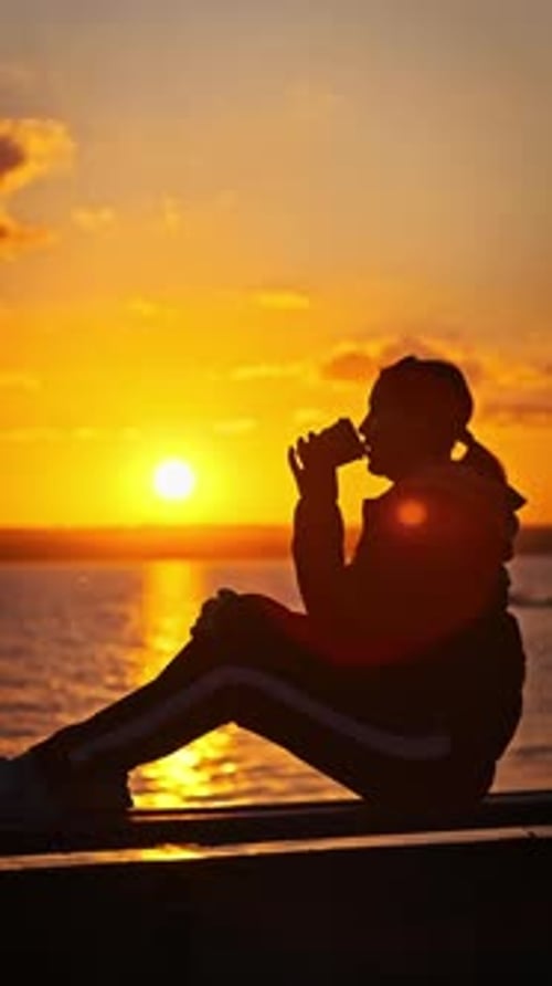 Vertical Silhouette Young Woman Drinks Coffee By Sunset Near Water Slow Motion