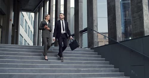Good Looking Young Male and Female Business Colleagues Walking the Steps Down From the Big Office